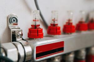 Water valve manifold with red caps aligned in a row, highlighting the intricate design. Used for efficient control and distribution of water flow in plumbing systems. photo