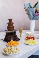 A table with plates of fruit and chocolate photo
