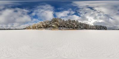 winter full spherical 360 hdri panorama view on ice of frozen snow-covered lake in middle of forest in equirectangular projection. VR AR content photo