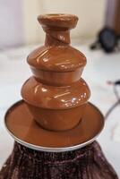 A chocolate fountain with a chocolate fountain on top photo