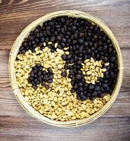 coffee beans in the shape of a yin and yang symbol with wood background for marketing photo