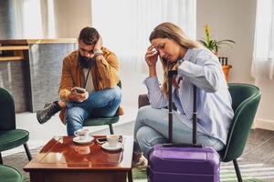 Man and woman sitting at lobby at airport and waiting for boarding. They are bored and tired. photo