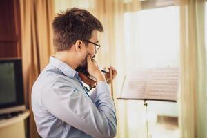 Man is practicing violin for live performance. photo