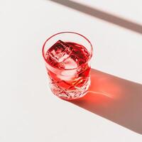 A red drink in a glass with ice photo