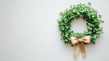 A wreath with green leaves and a bow on a white wall photo