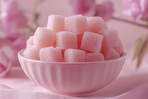A pink bowl overflowing with sweet, pink sugar cubes. photo