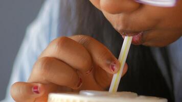 Enjoying a refreshing drink with colorful straw in warm cafe video