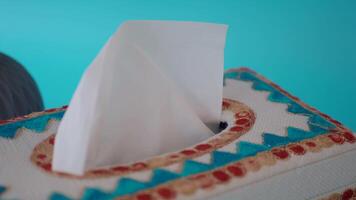 Decorative tissue box with colorful design on blue background video