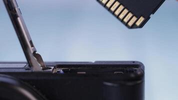 Inserting a memory card into a digital camera for storage expansion video