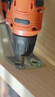Installing metal brackets with a power drill in a workshop video