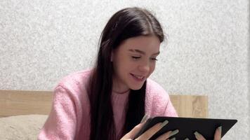 Young woman using tablet on bed changing facial expressions video