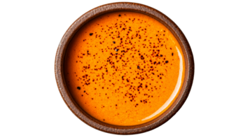 Orange soup with spices in a ceramic bowl, cut out transparent png