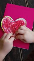 Vertical . Making DIY gift for Mothers day or Valentines day. Small child attach heart to DIY greeting card using plasticine. video