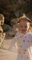 Happy little child girl running on ocean beach with sunset sunlight video