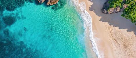 An aerial view of a tropical beach with turquoise water and green trees photo