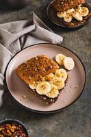 Toast rye bread with chocolate and banana on a plate on the table vertical view photo