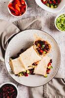 Vegetarian salsa rolls in tortilla on plate on table top and vertical view photo