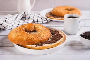Bagel sandwich with butter and grated chocolate on a plate on a table photo