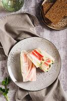Spring rolls with crab meat, cucumber and herbs on a plate on the table top and vertical view photo