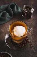 Affogato espresso coffee with vanilla ice cream in a cup on the table vertical view photo