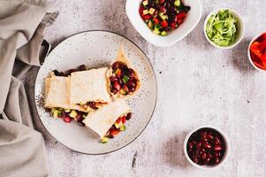 Salad of beans, cucumber and pepper in lavash rolls on a plate on the table top view photo