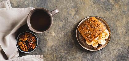 Toast rye bread with chocolate and banana on a plate on the table top view web banner photo