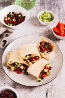 Vegetarian salsa rolls in tortilla on plate on table vertical view photo