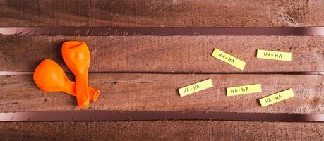 Happy April Fools Day, balloons and funny notes on wooden top view web banner photo