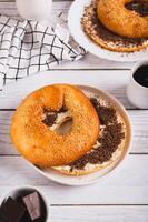 Sweet sandwich with butter, chocolate and sesame seeds on a plate on a table vertical view photo