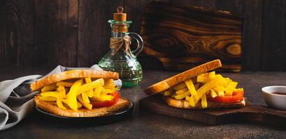 Fried toasts with french fries and tomato on a board on the table web banner photo