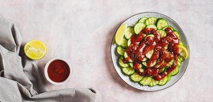 Delicious cucumbers with chili pepper and lime on a plate on the table top view web banner photo