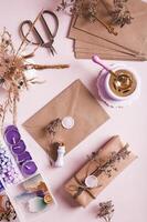 Craft envelope with wax seal and crafting items on pink top and vertical view photo