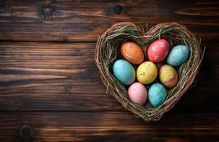 Easter Eggs in a Heart Basket on Rustic Wooden Background, Top View photo