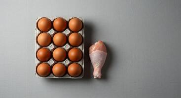 Chicken Leg and a Dozen Eggs on Grey Background photo