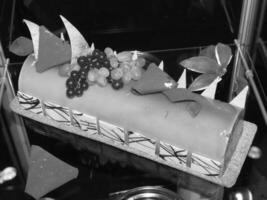 Decorative Yule Log Cake with Grapes and Chocolate Accents for different design purposes photo