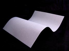 Wavy paper sheet over black background wallpaper design photo