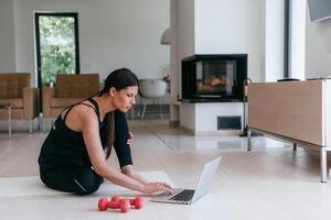 Young Beautiful Female Exercising, Stretching and Practising Yoga with Trainer via Call Conference in Bright Sunny House. Healthy Lifestyle, Wellbeing and Mindfulness Concept. photo