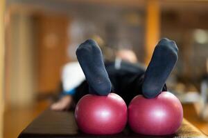 A close up shot of a patients legs resting on rehabilitation balls, aiding in recovery and improving flexibility during therapy. photo