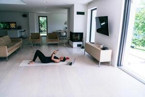 Sportswoman using a smartphone while resting and lying on the floor of modern house. photo