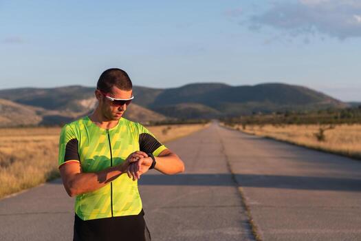 The triathlete checking his training statistics on a smartwatch, analyzing his performance and progress. With dedication, discipline, and perseverance, he strives to improve his physical abilities and photo