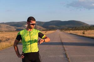 The triathlete checking his training statistics on a smartwatch, analyzing his performance and progress. With dedication, discipline, and perseverance, he strives to improve his physical abilities and photo