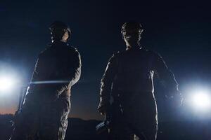 Two professional soldiers marching through the dark of night on a dangerous mission, epitomizing their unwavering bravery, unwavering teamwork, and the high-stakes intensity of their specialized photo