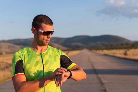 The triathlete checking his training statistics on a smartwatch, analyzing his performance and progress. With dedication, discipline, and perseverance, he strives to improve his physical abilities and photo