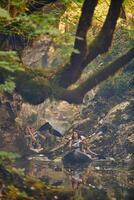 A group of friends enjoying having fun and kayaking while exploring the calm river, surrounding forest and large natural river canyons photo