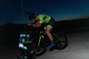 A videographer recording a triathlete riding his bike preparing for an upcoming marathon.Athlete's physical endurance and the dedication required to succeed in the sport. photo