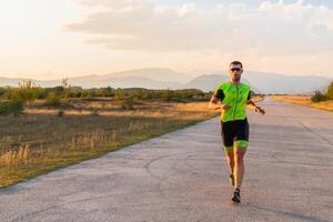 Triathlete in professional gear running early in the morning, preparing for a marathon, dedication to sport and readiness to take on the challenges of a marathon. photo