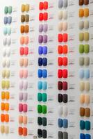 A row of nail polish colors are displayed on a wall photo