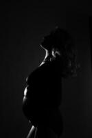 silhouette of a pregnant woman shooting on the background in the studio photo