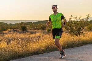 Triathlete in professional gear running early in the morning, preparing for a marathon, dedication to sport and readiness to take on the challenges of a marathon. photo