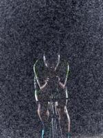 A triathlete braving the rain as he cycles through the night, preparing himself for the upcoming marathon. The blurred raindrops in the foreground and the dark, moody atmosphere in the background add photo